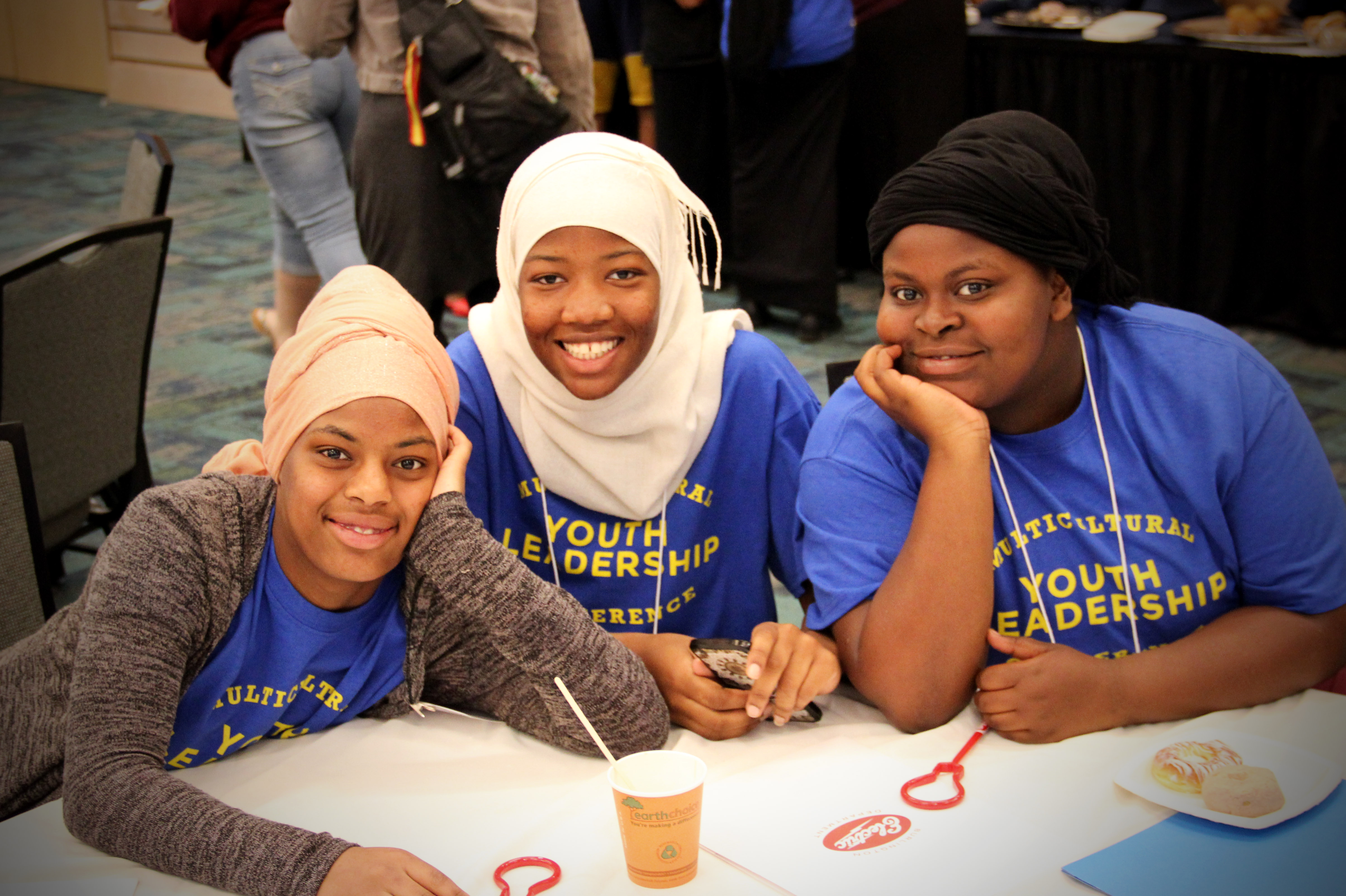 three youth smiling at the conference